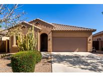Charming single-story home with desert landscaping, tile roof, and a two-car garage, all under a clear blue sky at 37852 W Merced St, Maricopa, AZ 85138