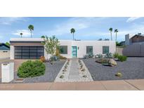 Stunning modern home featuring a sleek design, desert landscaping, and inviting turquoise-colored door at 15028 N 9Th St, Phoenix, AZ 85022