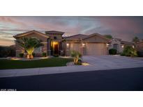 Charming single-story home with a three-car garage, well-manicured lawn, and stone accents at 15664 W Vernon Ave, Goodyear, AZ 85395