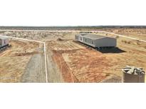 New construction home showing the exterior with dirt landscaping and a water tank at 23134 W Duane Ln, Wittmann, AZ 85361