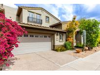 Charming two-story home featuring a two-car garage and vibrant bougainvillea bushes at 20802 N Grayhawk Dr # 1005, Scottsdale, AZ 85255