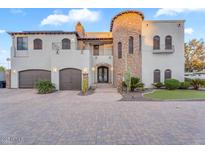 Stunning two-story home featuring a stone tower, two-car garage, and beautiful desert landscaping at 3675 N 59Th Pl, Phoenix, AZ 85018