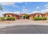 Stunning single-story home with desert landscaping and a circular brick driveway leading to attached garages at 3816 E Expedition Way, Phoenix, AZ 85050