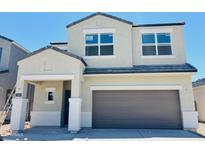 Two-story home featuring a two-car garage, covered porch, and a modern design with neutral stucco and tile roof at 5075 E Umber Rd, San Tan Valley, AZ 85143