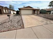 Charming single-story home with a large driveway and attached two-car garage at 6231 W Zoe Ella Way, Glendale, AZ 85306