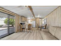 An open-concept living area featuring wood-look floors, and a sliding glass door at 8103 E Southern Ave # 268, Mesa, AZ 85209