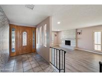 Inviting home foyer with a solid wood front door, tile floors, and a glimpse of the living room at , Glendale, AZ 85302