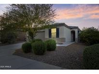 Charming single-story home featuring desert landscaping and a well-maintained front yard at dusk at 19984 W Washington St, Buckeye, AZ 85326