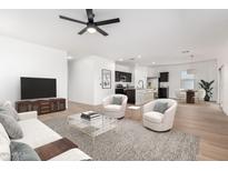 Bright living room featuring stylish furniture, a ceiling fan, and a view into the modern kitchen at 20116 W Monroe St, Buckeye, AZ 85326