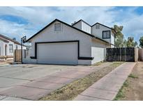 White two story home with black trim and a large 2-car garage with driveway at 3827 N 88Th Ln, Phoenix, AZ 85037