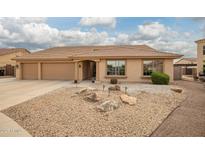Inviting single-story home showcasing a well-maintained yard with decorative rock and a spacious three-car garage at 4909 W Pedro Ln, Laveen, AZ 85339