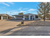 Charming single-story home with desert landscaping, covered carport, and inviting blue chairs on the front porch at 6913 W Wilshire Dr, Phoenix, AZ 85035
