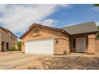 Tan single Gathering house with a white door and white garage door at 9167 N 73Rd Ln, Peoria, AZ 85345