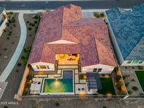 Aerial view of the backyard with a refreshing pool, pergola, and manicured landscaping at 17396 W Crawfordsville Dr, Surprise, AZ 85388