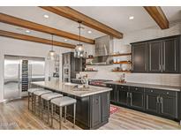 Modern kitchen with stainless steel appliances, a large island, and stylish pendant lighting at 17396 W Crawfordsville Dr, Surprise, AZ 85388