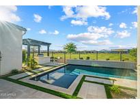 Stunning pool area with outdoor kitchen and serene golf course views offers the perfect relaxation spot at 17396 W Crawfordsville Dr, Surprise, AZ 85388