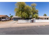 Charming single-story home featuring a well-maintained yard, mature trees and a classic white picket fence at 20816 E Duncan St, Queen Creek, AZ 85142