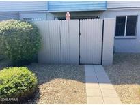 Exterior view of home featuring a private courtyard with a privacy fence and desert landscaping at 2602 W Berridge Ln # C102, Phoenix, AZ 85017