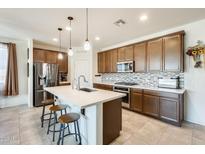 Modern kitchen with quartz countertops, stainless steel appliances, and tile backsplash at 2813 W Apollo Rd, Phoenix, AZ 85041