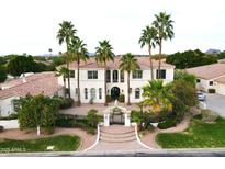 An aerial view of a two-story home with palm trees, tiled roof, iron gate, and lush landscaping at 3306 E Jaeger Cir, Mesa, AZ 85213