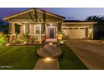 Inviting home featuring desert landscaping, a well-lit brick pathway, and a covered porch at 4876 N 207Th Ln, Buckeye, AZ 85396