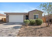 Charming single-story home featuring a two-car garage, low-maintenance landscaping and a desert-style front yard at 697 E Ruby Dr, Casa Grande, AZ 85122