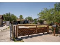 A single Gathering home featuring a unique wood and metal gated entry and a well-maintained front yard at 1108 S Lebanon Ln, Tempe, AZ 85288