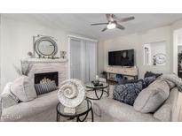 Cozy living room featuring a fireplace, ceiling fan, and neutral decor, perfect for relaxing and entertaining guests at 15252 N 100Th St # 1154, Scottsdale, AZ 85260