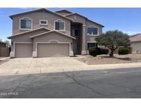 Two-story home with a neutral stucco exterior, three-car garage, and tidy landscaping at 43324 W Desert Fairways Dr, Maricopa, AZ 85138
