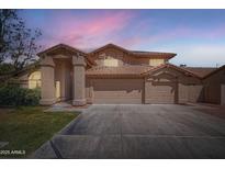 Exterior elevation of a two-story home with a three-car garage under a dusk sky at 514 E Vaughn Ave, Gilbert, AZ 85234