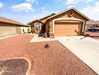 Single-story home with a gravel front yard and a two-car garage on a sunny day at 14950 W Rockrose Way, Surprise, AZ 85374