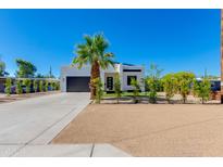 Modern white home with desert landscaping, black trim, palm tree and concrete driveway at 2927 E Osborn Rd, Phoenix, AZ 85016