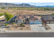 Expansive home with landscaped yard, circular entryway, 3-car garage, and mountain views at 3125 W Desert Ln, Laveen, AZ 85339