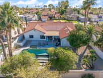 Stunning aerial view of a home featuring a private pool, patio, and beautiful landscaping with palm trees at 10248 E San Salvador Dr, Scottsdale, AZ 85258