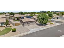 Expansive home features a 3 car garage, desert landscaping, and solar panels for energy efficiency at 1182 E Canyon Way, Chandler, AZ 85249
