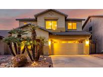 Charming two-story home with a well-manicured yard featuring desert landscaping and palm trees at 14228 W Weldon Ave, Goodyear, AZ 85395