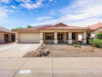 Charming single-story home featuring a tile roof, covered porch, and a xeriscaped front yard at 17210 N Cassi Dr, Surprise, AZ 85374