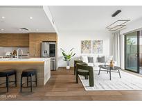 Bright living room featuring hardwood floors and a modern kitchen island with counter seating at 2300 E Campbell Ave # 106, Phoenix, AZ 85016