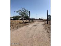 Gravel driveway leading to gated rural property on a sunny day at 2637 S Amanda Dr, Maricopa, AZ 85139