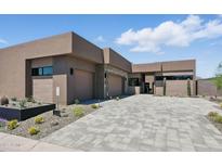 Contemporary home boasts a spacious driveway, three-car garage, and desert landscaping for enhanced curb appeal at 37200 N Cave Creek Rd # 1013, Scottsdale, AZ 85262