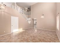 Spacious living room featuring a staircase, high ceilings, tile flooring, and abundant natural light at 4347 W Darrel Rd, Laveen, AZ 85339