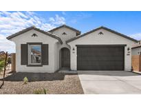 Charming single-story home featuring a two-car garage, neutral stucco, and manicured desert landscaping at 7643 W Park St, Laveen, AZ 85339