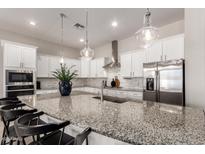 Bright and airy kitchen featuring white cabinets, granite countertops, stainless steel appliances, and pendant lighting at 19038 N Arbor Dr, Maricopa, AZ 85138