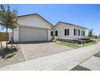 Charming single-story home with a two-car garage, beautiful landscaping, and a welcoming brick driveway at 2153 E Cherrywood Pl, Chandler, AZ 85249