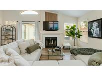 Bright living room with a fireplace, large sectional sofa, modern decor, and ample natural light at 21940 N 69Th Dr, Glendale, AZ 85310