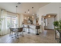 Bright kitchen and dining area with modern pendant lighting, counter seating and open layout at 2394 E Santiago Trl, Casa Grande, AZ 85194