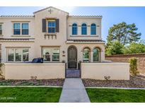 Charming two-story townhouse featuring a stucco facade, arched windows, and a landscaped front yard at 4077 S Sabrina Dr # 14, Chandler, AZ 85248