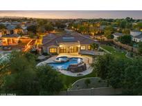 Aerial view of a luxury home showcasing a beautiful backyard pool with a rock waterfall feature and lush landscaping at 4547 S Banning Dr, Gilbert, AZ 85297