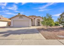 Charming single-story home with a well-manicured yard, two car garage, and a beautiful blue sky at 515 W Smoke Tree Rd, Gilbert, AZ 85233