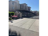 The building's exterior has a gated entrance, a covered parking, landscaping and a concrete entrance at 7609 E Indian Bend Rd # 1012, Scottsdale, AZ 85250